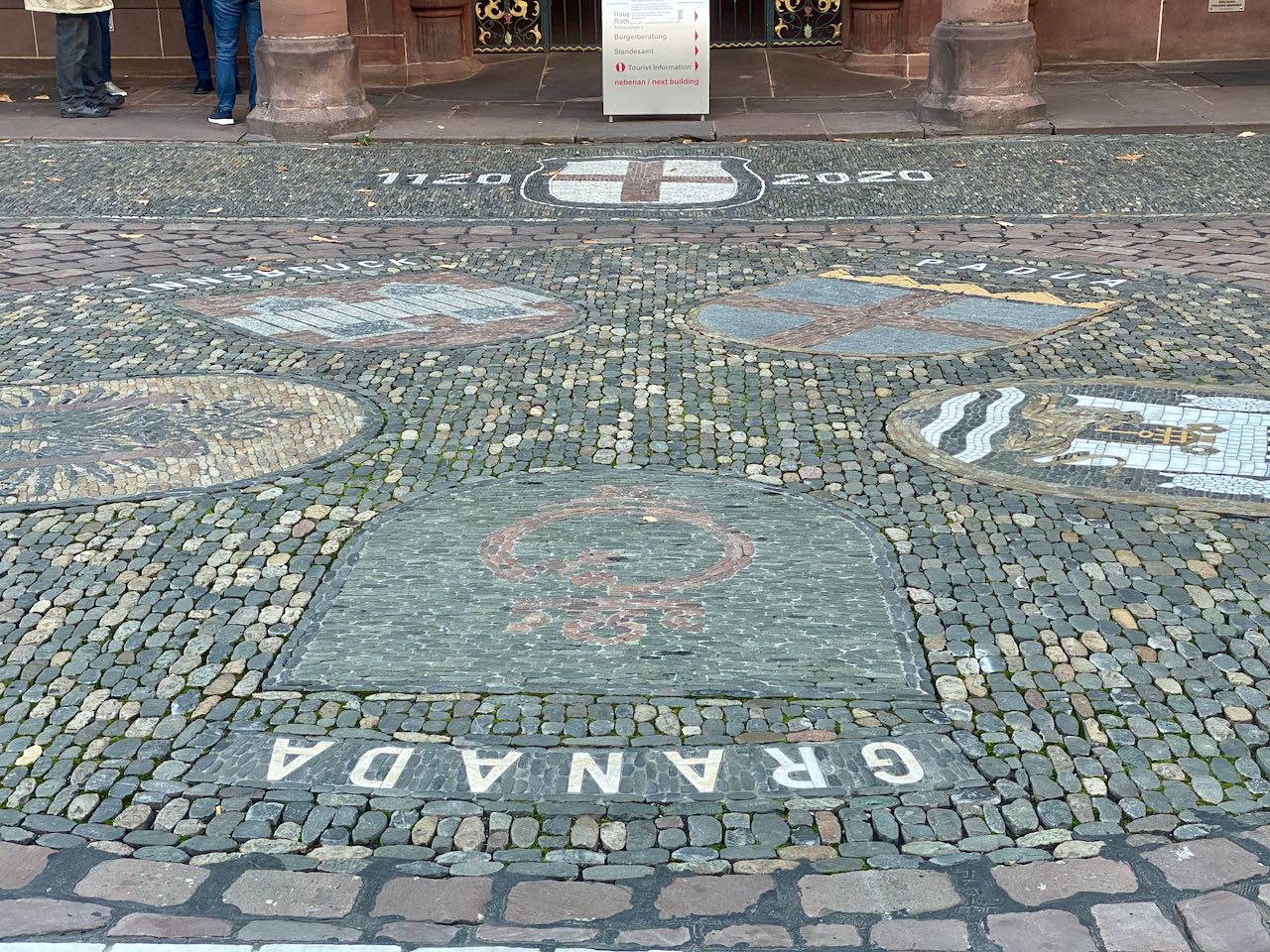 Wappen der Partnerstädte Freiburgs aus Pflastersteinen, im Vordergrung Granada